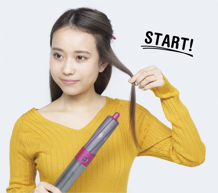 女性が新発売したDyson Airwrapを試しているところ。