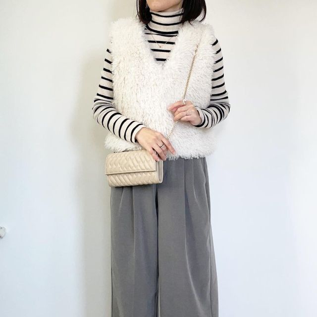 エクストラファインメリノリブタートルネックセーターとベストの全身コーデ