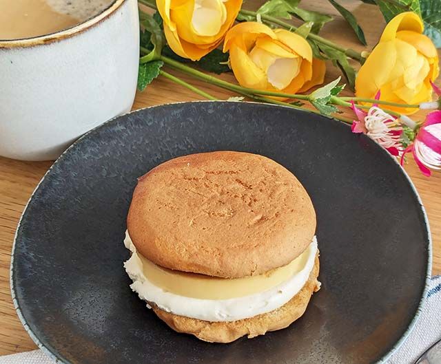 【ローソン新商品】「ふわどらサンド」とコーヒー、花がテーブルに置かれた様子