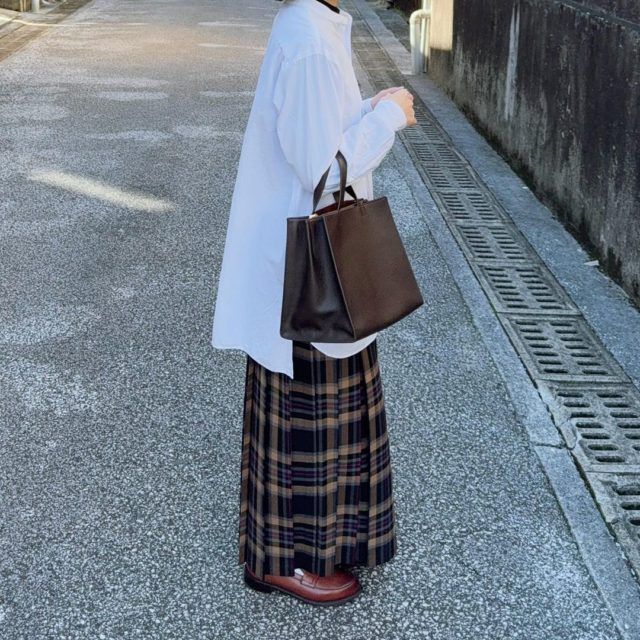 ブラウン系チェックロングスカートを穿く女性