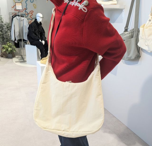 白のソフトナイロンラウンドショルダーバッグを着用