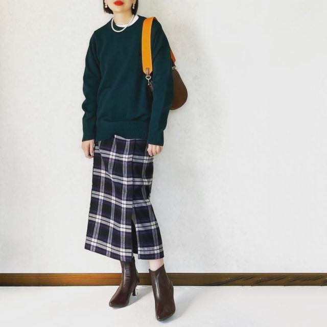 ミディ丈のチェックスカートを穿く女性