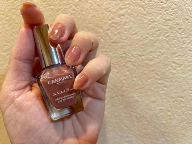 ピンクのネイルを持っている