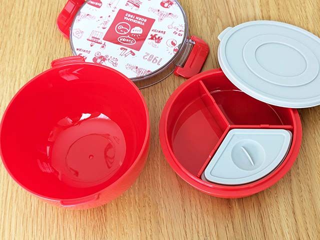 「すき家オリジナルランチボックス」の中ブタ付きの容器のとご飯を分入れられる容器がテーブルに並べられている様子。