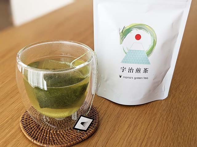 宇治煎茶のパッケージと、ティーパックがで入れられたお茶のカップ