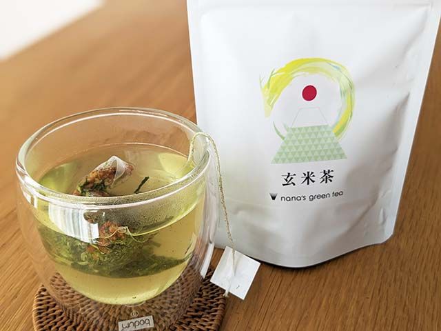 玄米茶のパッケージと、ティーパックがで入れられたお茶のカップ