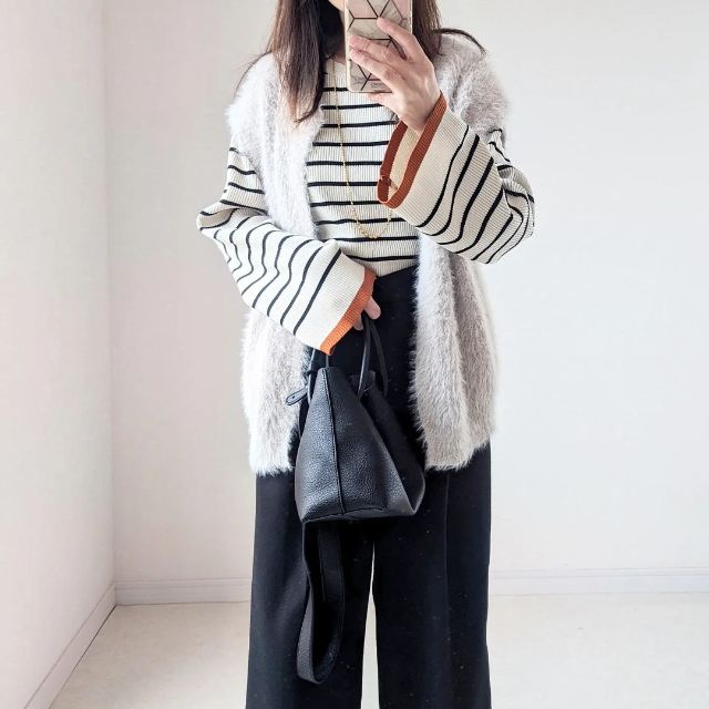 白黒のボーダーニットと黒のスラックスの全身コーデ