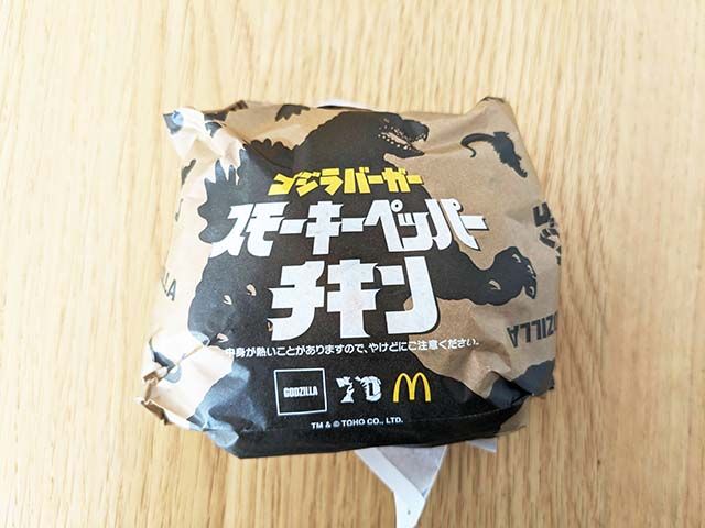 ゴジラデザインの包装紙に包まれた【マクドナルド】新商品「スモーキーペッパーチキン」