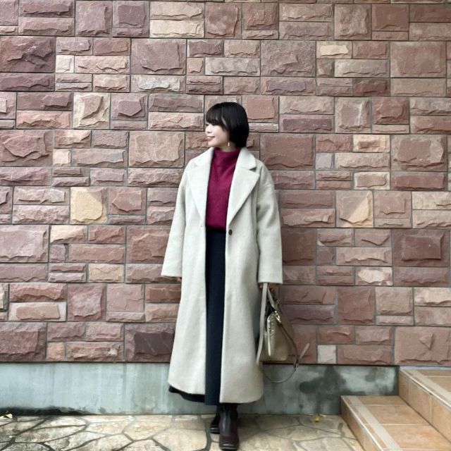 アイボリーのシャギー素材コートとワインレッドのニットトップスの全身コーデ