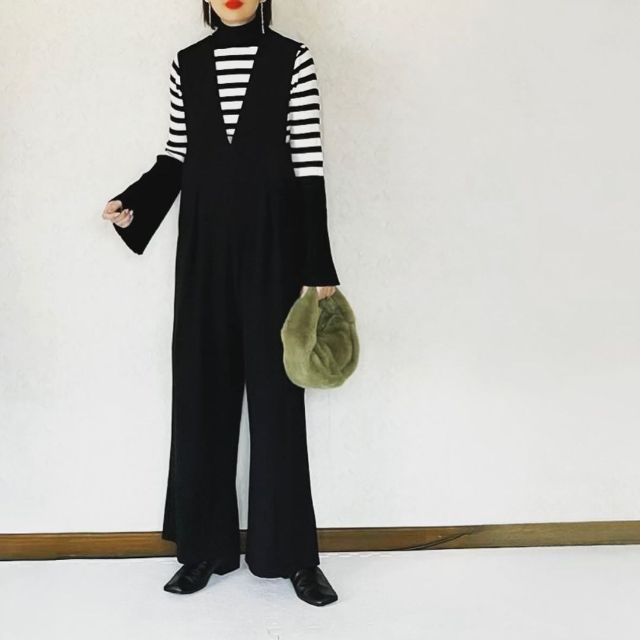 白黒のボーダー柄ニットと黒のオールインワンの全身コーデ