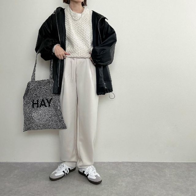 黒のブルゾンジャケットと白のニットトップスの全身コーデ