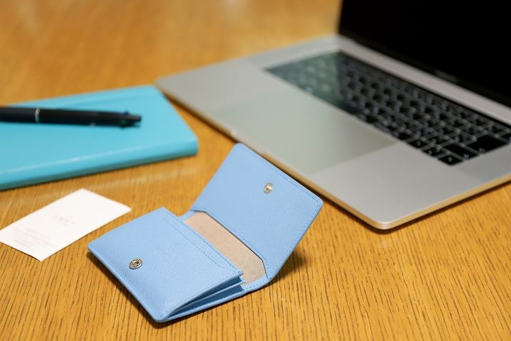 ブルーの名刺入れと手帳、ノートパソコン