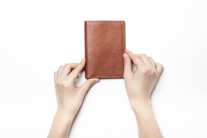 革製の名刺入れを持つ手