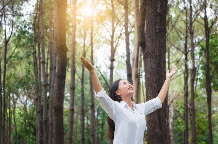 自然の中で深呼吸する女性