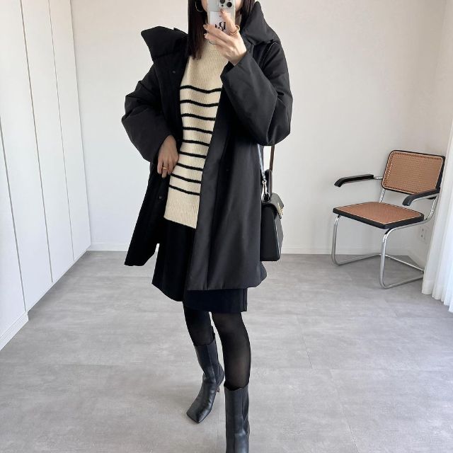 黒のダウンロングコートと白黒のボーダーニットと黒のハーフパンツの全身コーデ