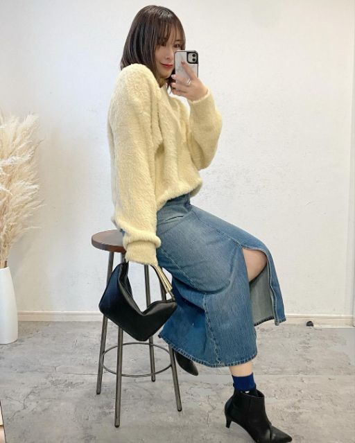 UNIQLOのデニムロングスカートを着用して椅子に座っている