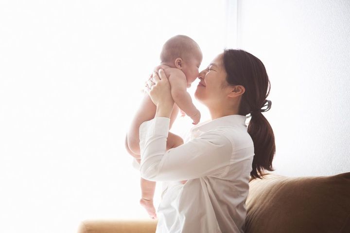 乳幼児を抱き上げ、鼻をつけて思い切りかわいがっている母親