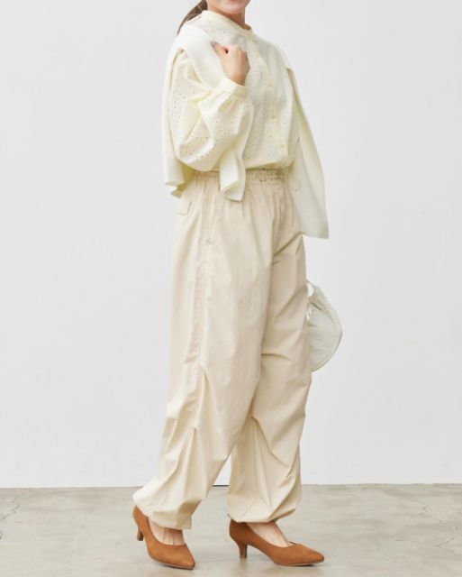 白のパラシュートパンツを着用している