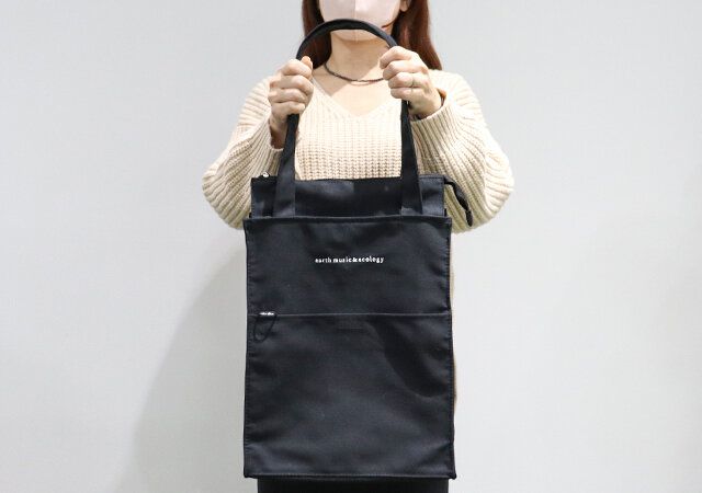 アース ミュージック＆エコロジーのイベントトートバッグ BLACKを持っている様子