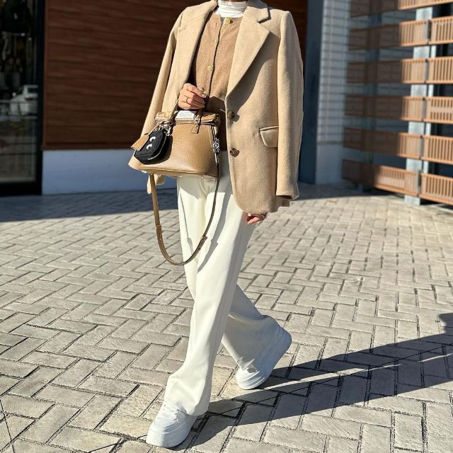 ベージュのテーラードジャケット×ベージュのカーディガン×白のスラックスの全身コーデ