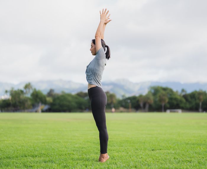 つま先立ち、両手を上に伸ばす