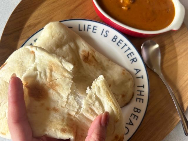 ナンを左手でちぎってみせている