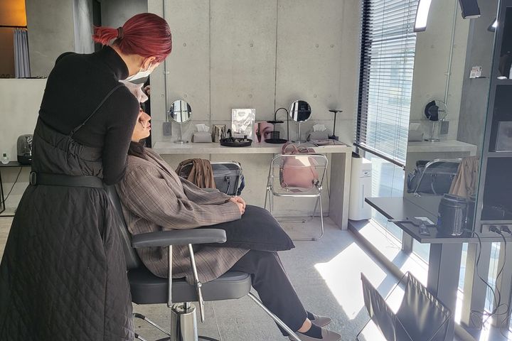 スタッフHの眉毛を理想的な形に――。さっそうと施術を進めるSAKURAさん（左）