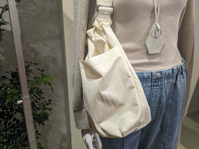 白のナイロンドローストリングショルダーバッグを着用