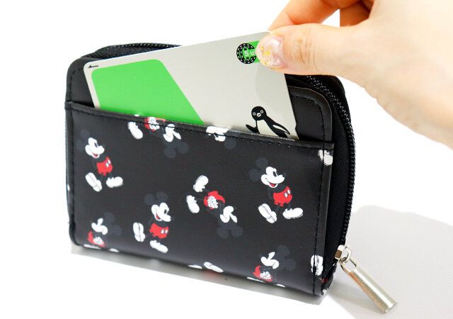 ミッキーマウスのミニ財布の背面ポケットからカードを取り出している画像