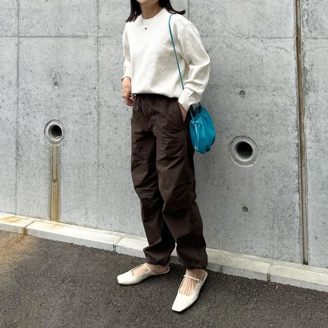 メンズのパラシュートと白ニットを着用したコーデ