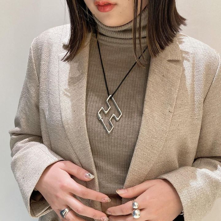 シルバーのネックレスと指輪をつけた女性