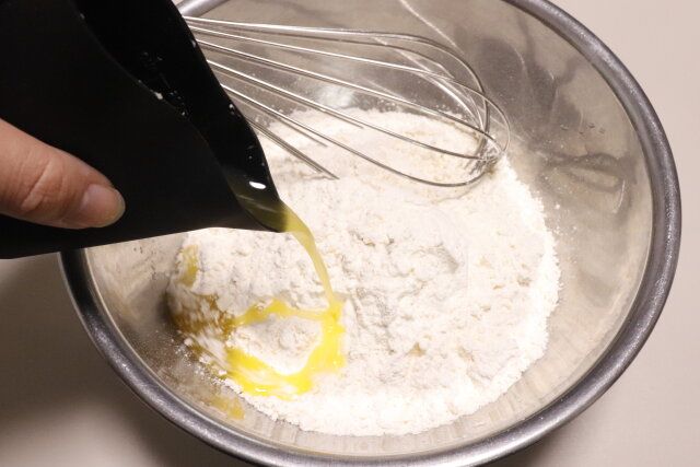 セリアのチョコやバターをレンジで溶かせるカップから溶かしバターを注ぐ様子