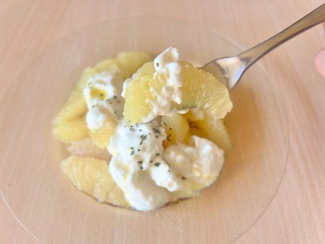 グレープフルーツとヨーグルトのサラダをフォークですくっている