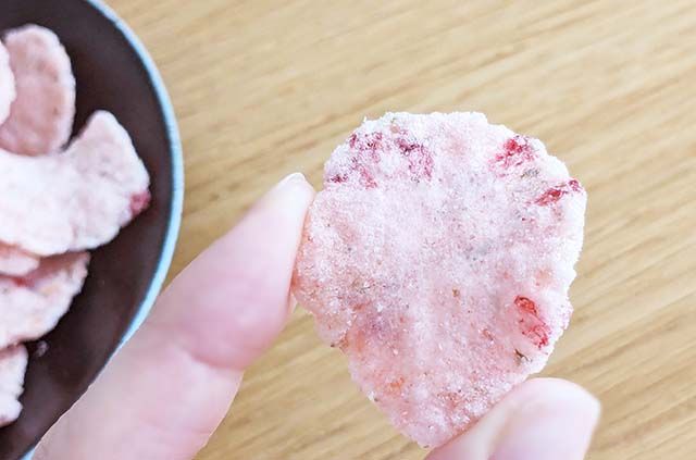 「カルディ 桜せんべい」を指で摘んでいる様子