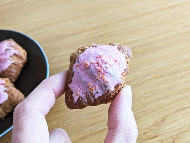 「カルディ オリジナル さくらクロワッサンラスク」を指で摘んでいる様子