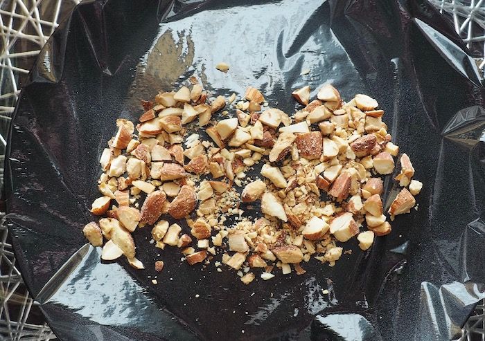 ラップの上に砕いたナッツを広げる