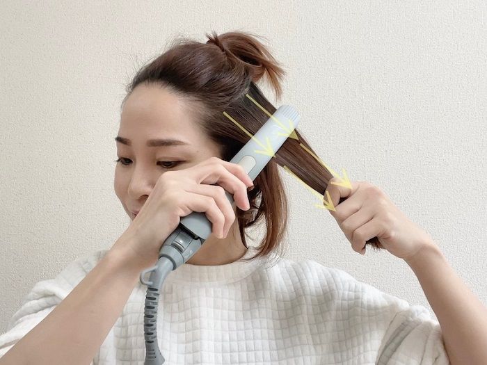 １ブロックにした髪の束ずつヘアアイロンを当てる