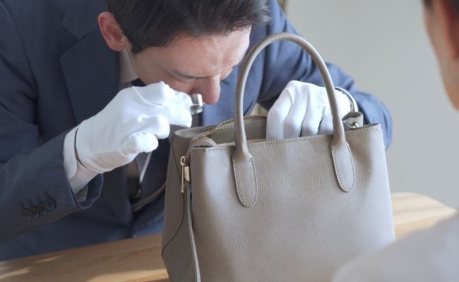 バックを査定する男性