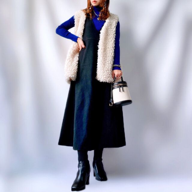 ユニクロのブルーのセーターに黒のワンピースとプードルファーの白ベストコーデ