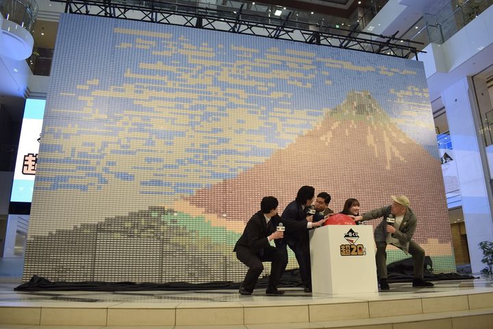 「くじ券で作る最大のモザイクアート」でギネス世界記録を達成した登壇者たち。一番右がくっきー！さん