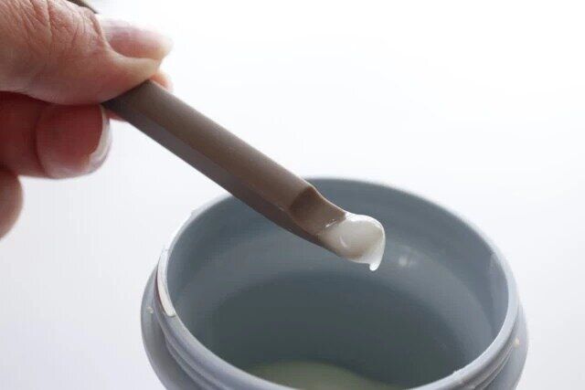 ダイソーのシリコーン スプーン＆スパチュラ 吸盤ホルダー付きの小さい方でクリームをすくいとる様子