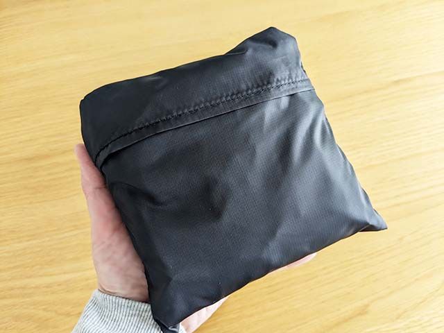 たたんだ状態の無印良品「たためる 撥水リュックサック」を手のひらにのせた様子