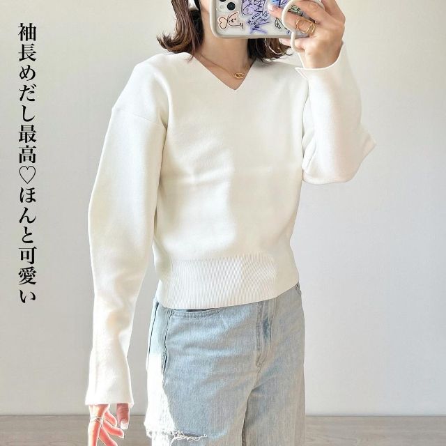 白のボリュームスリーブVネックセーターを着用