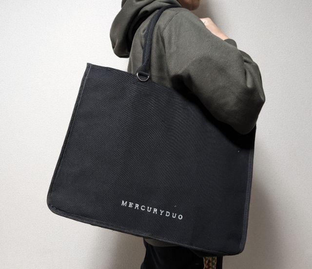 ブラックカラートートバッグを持った