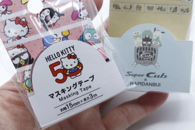 セリアのマスキングテープ M／X 50周年 パーティータイム！とSUPER CUB×はぴだんぶい マスキングテープ（切手風）のパッケージ