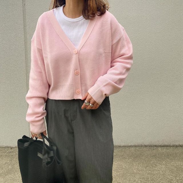 GUのピンクのウォッシャブルクロップドカーディガンを着用している