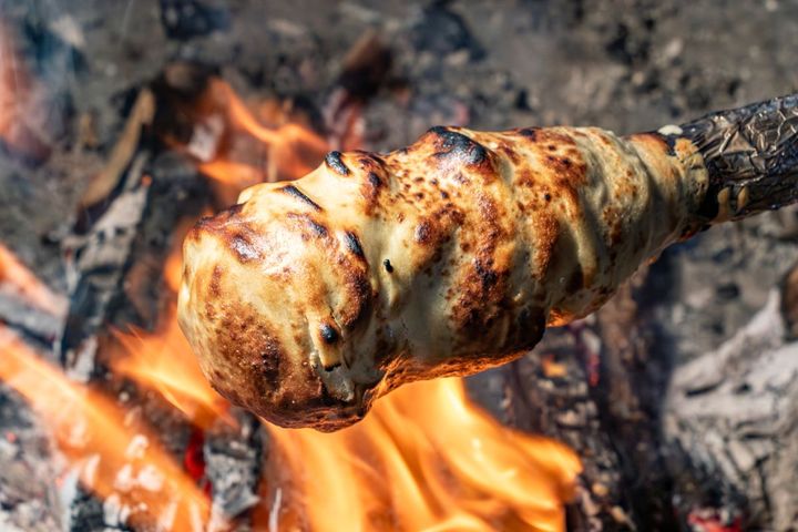 長い棒にバームクーヘンの生地をかけて、焚き火の上でクルクル。何度も繰り返します
