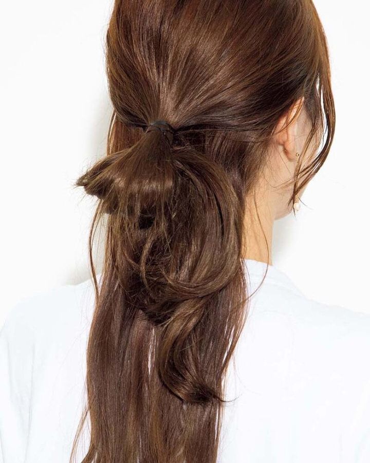 【1】耳の上の髪を集め、後頭部で毛先を抜き切らずにお団子状に結ぶ。ハーフアップの状態に。