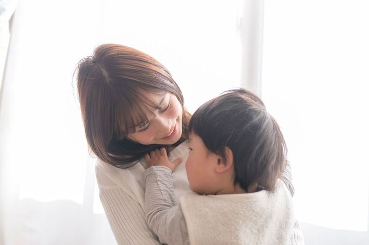 抱っこした子供に話しかけている母親