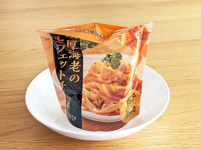 カルディ新商品「濃厚海老の生フェットチーネ レンジアップ」を袋ごと耐熱皿に載っている様子
